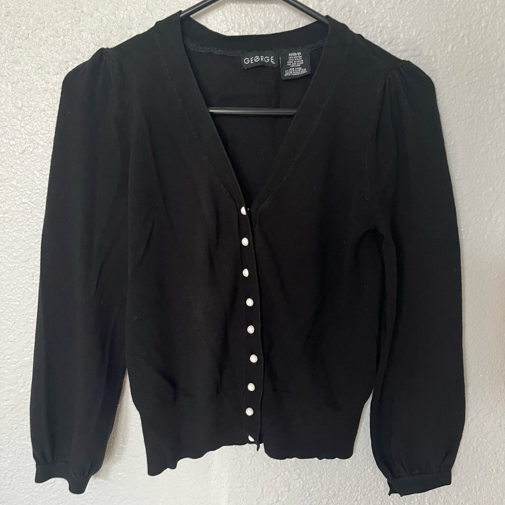 Black cardigan with pearly white buttons.